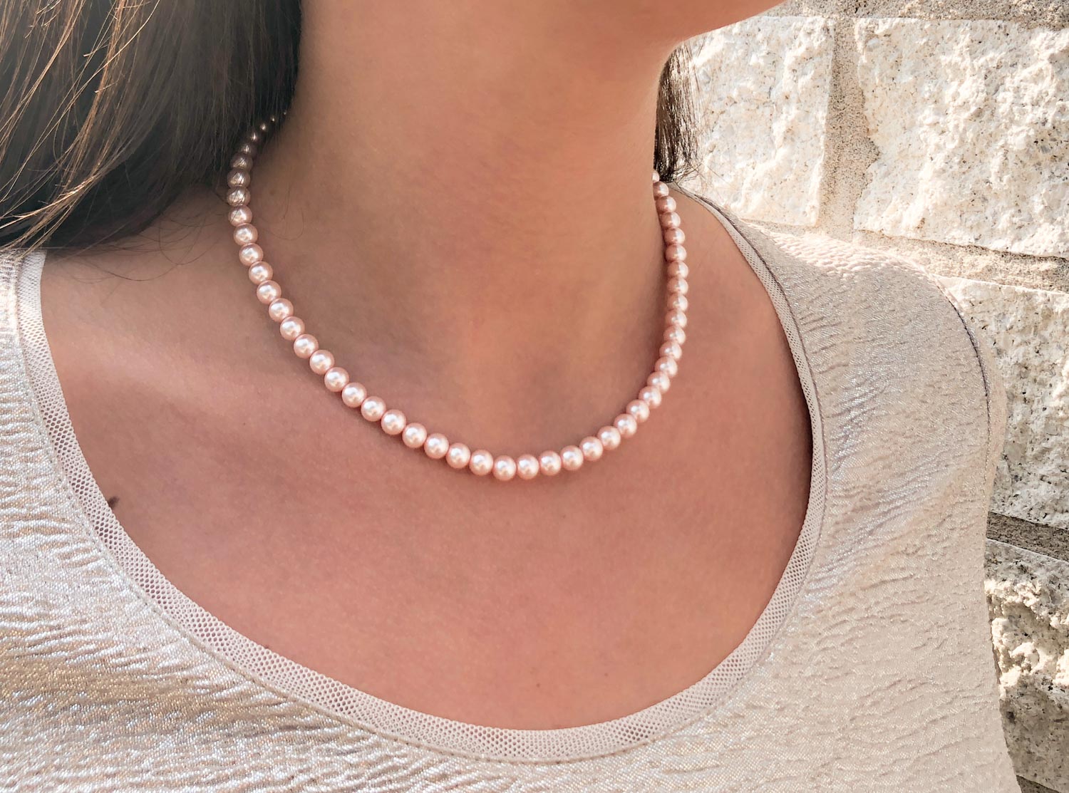 Vrouw draagt roze parelketting