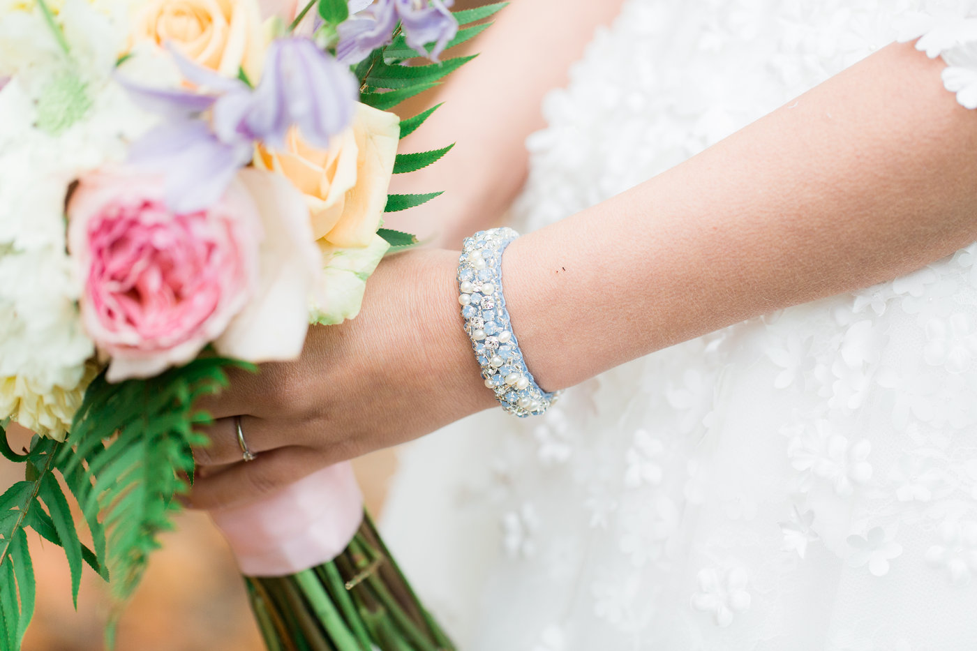 Blauwe bruidsarmband bij bruid met bruidsboeket