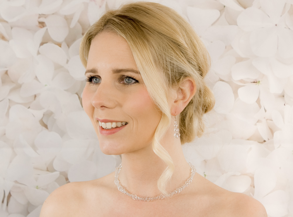 Vrouw met blond haar en parel ketting