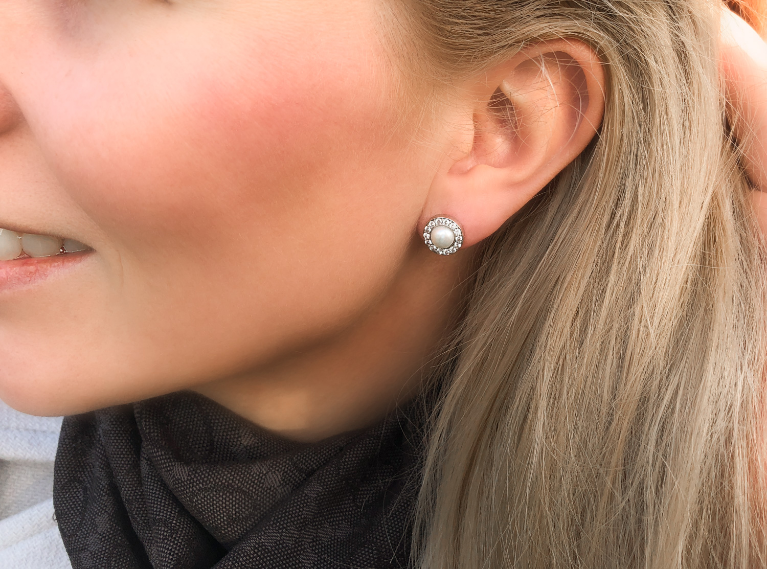 Vrouw met blond haar met parel stud oorbellen