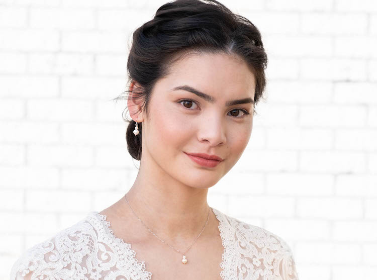 Vrouw draagt de Jara Pearl set met oorbellen en ketting