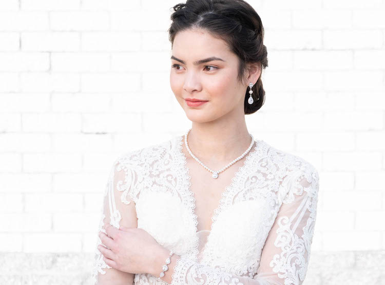 Vrouw draagt parel sieradenset met oorbellen armband