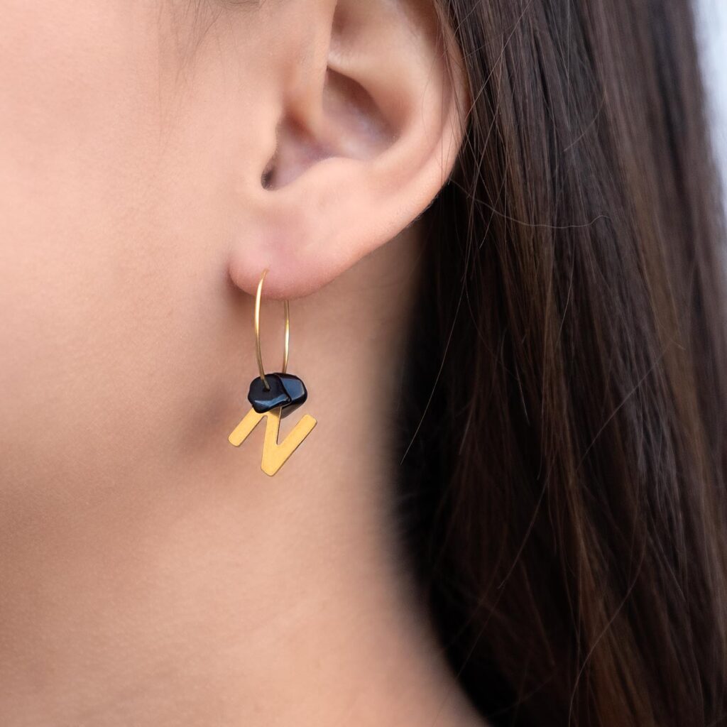 Gouden initial oorbellen met zwarte steentjes