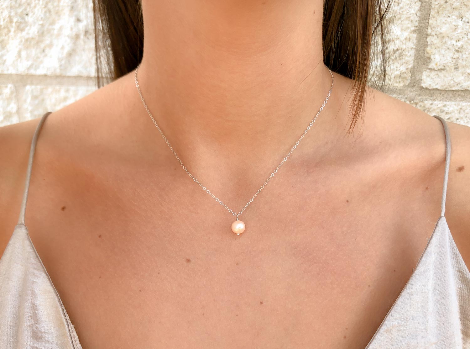 Vrouw met zilveren parelketting peach