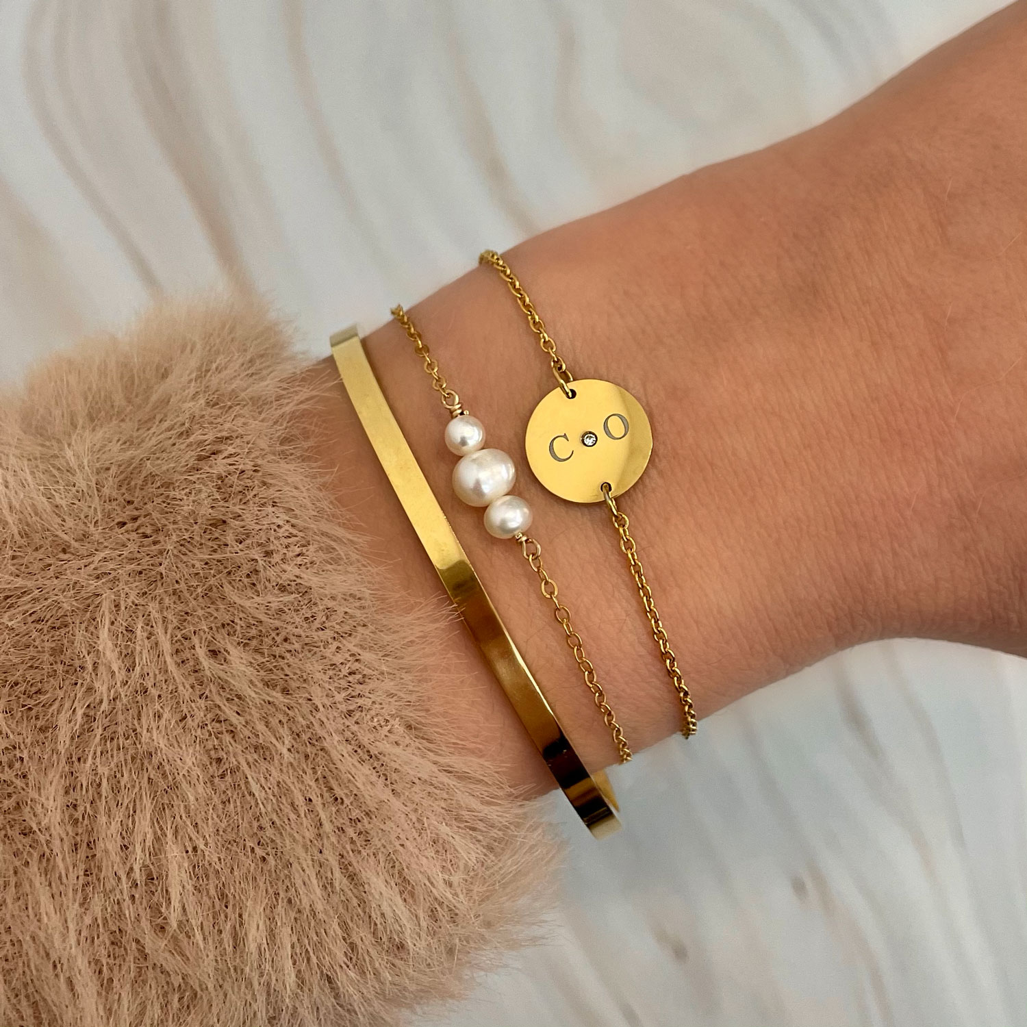 drie gouden armbandjes met gravering en parels