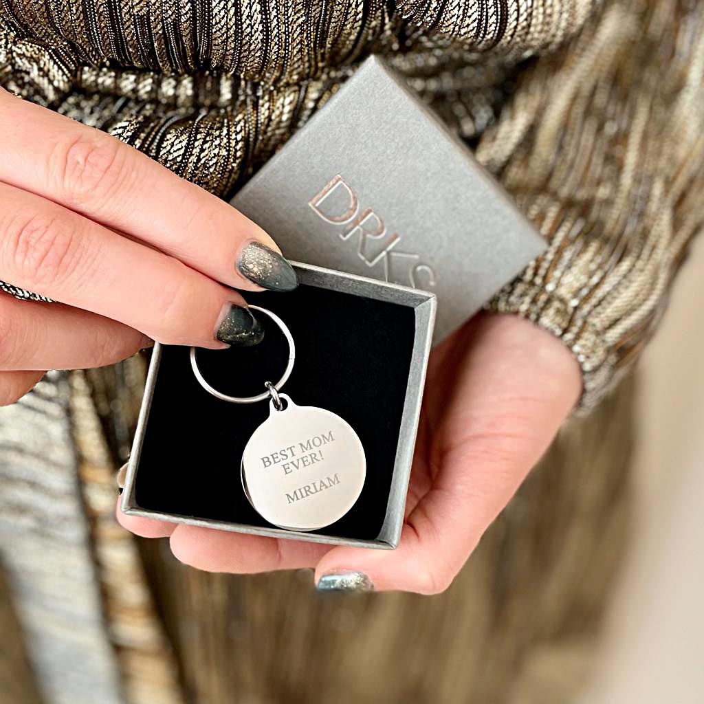 zilveren sleutelhanger rond met gravering in doosje