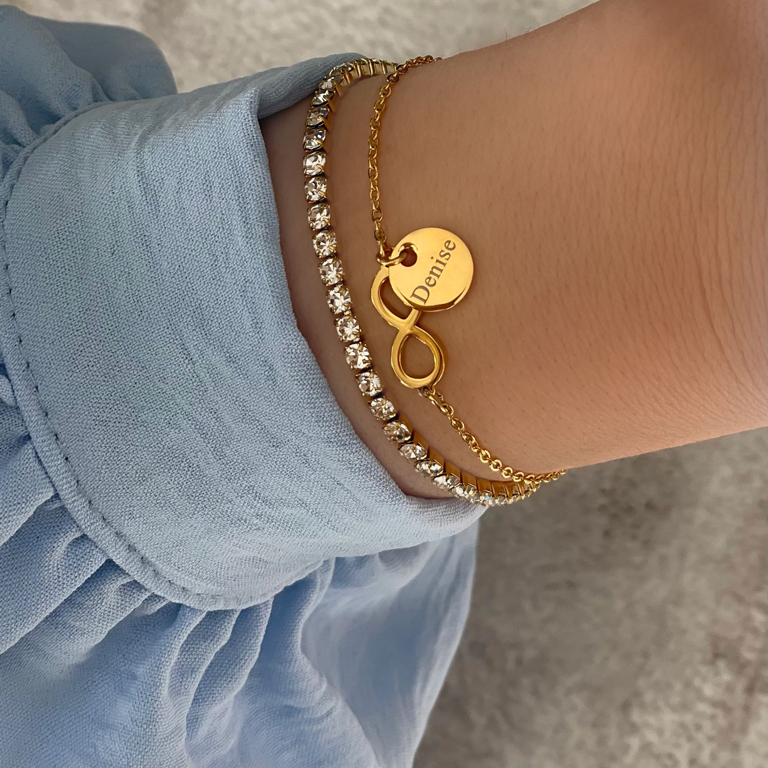 gouden armparty met gravering om pols