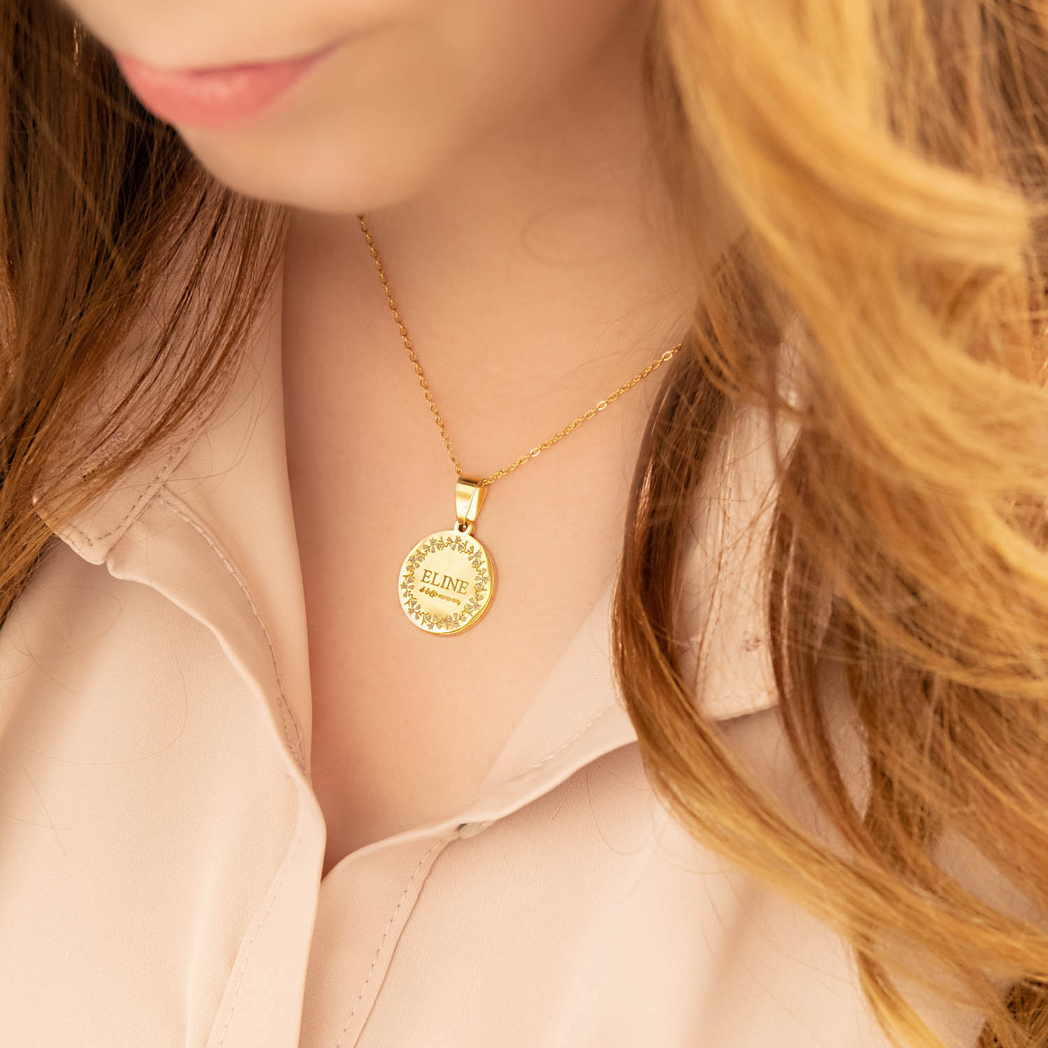 vrouw draagt gouden ketting met gravering