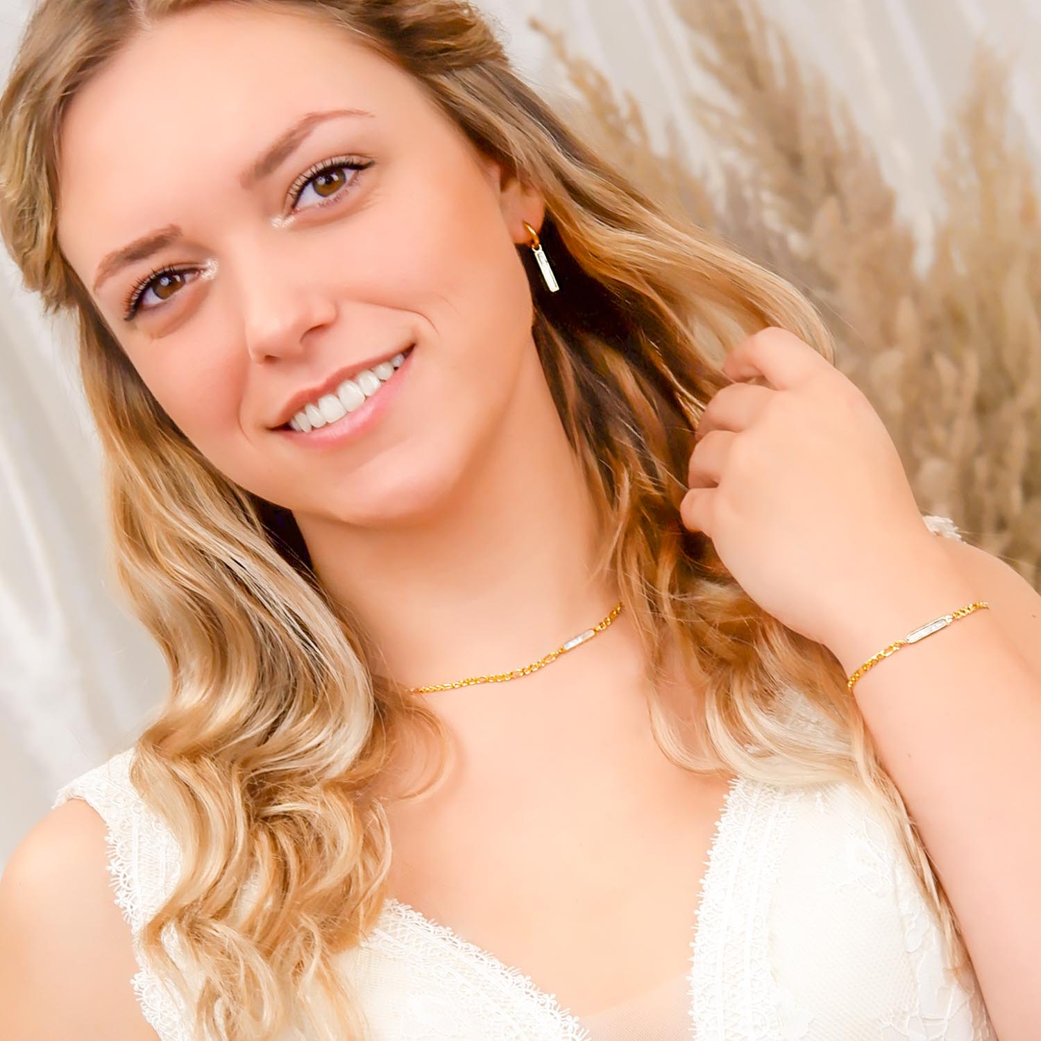 bruid draagt gouden sieradenset met parelmoer