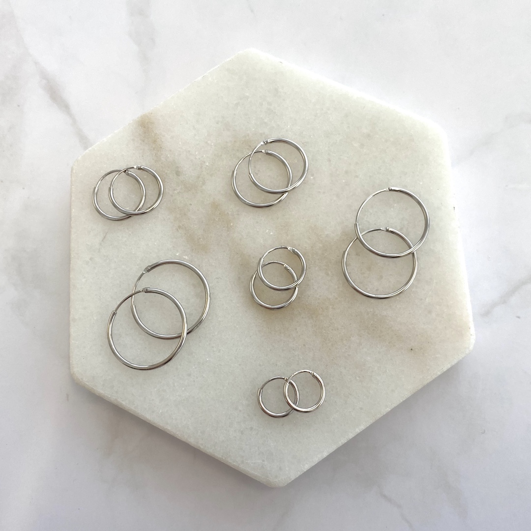 zilveren oorringetjes op marmeren plateau