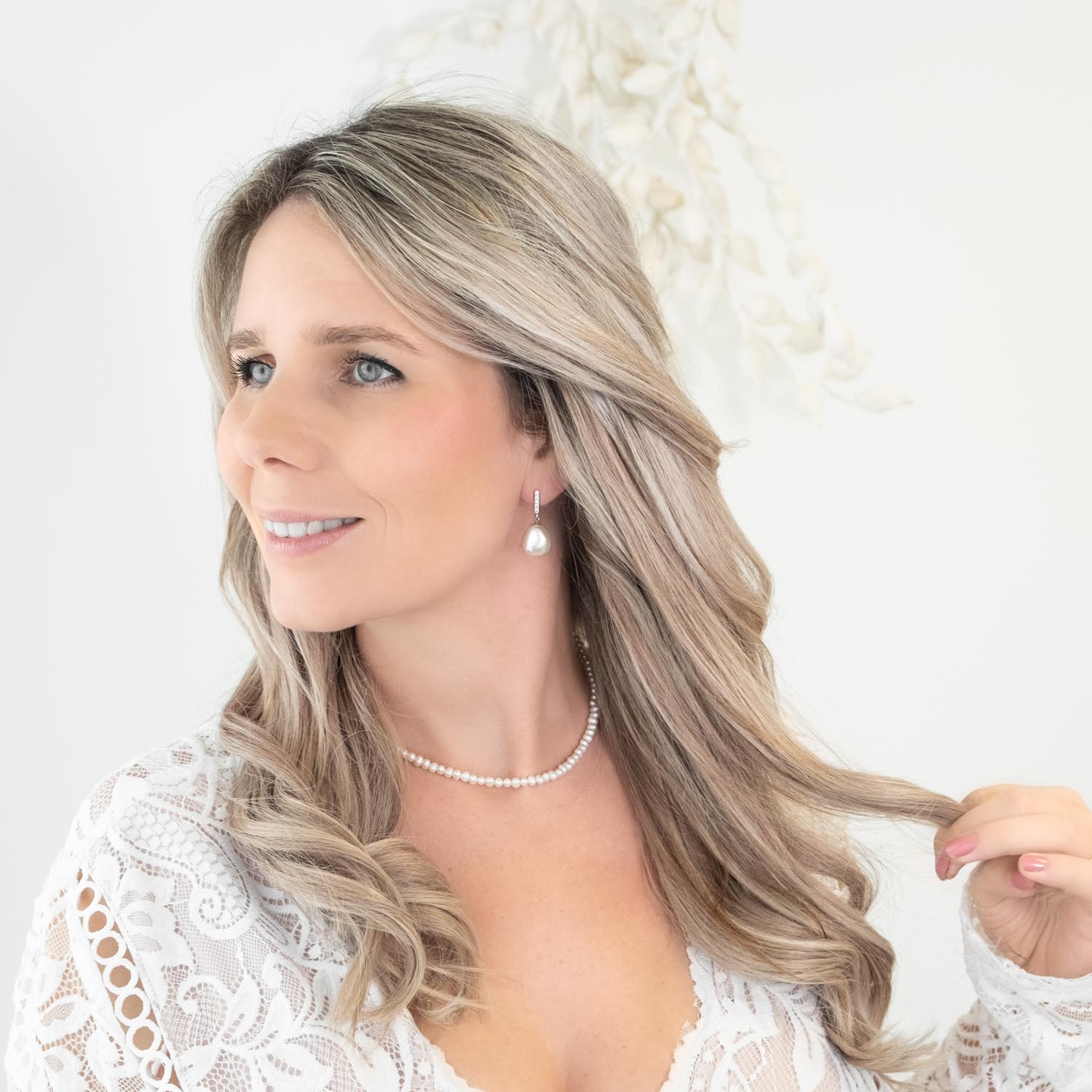 bruid draagt parelketting en oorbellen