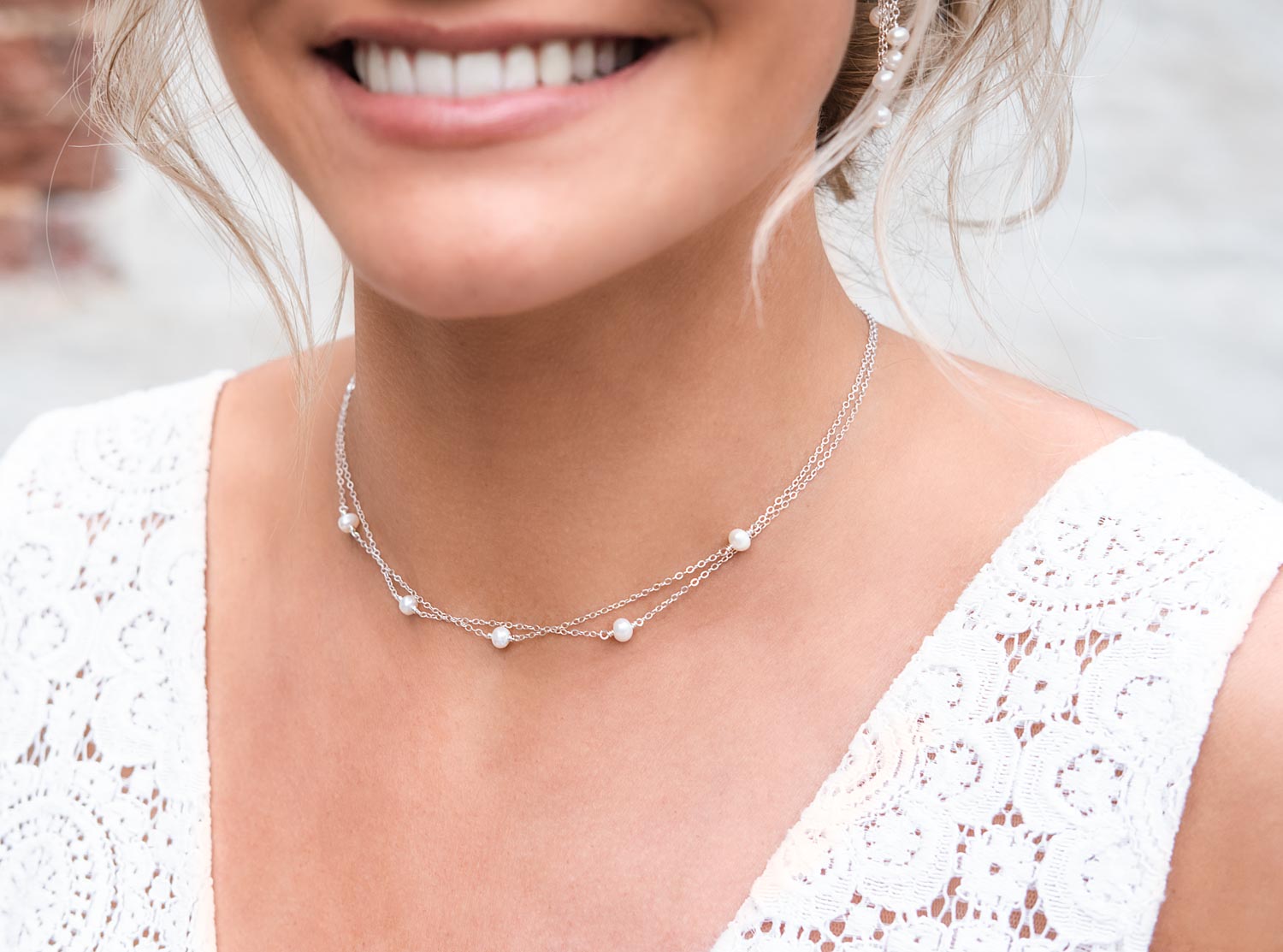 bruid draagt zilveren ketting met pareltjes