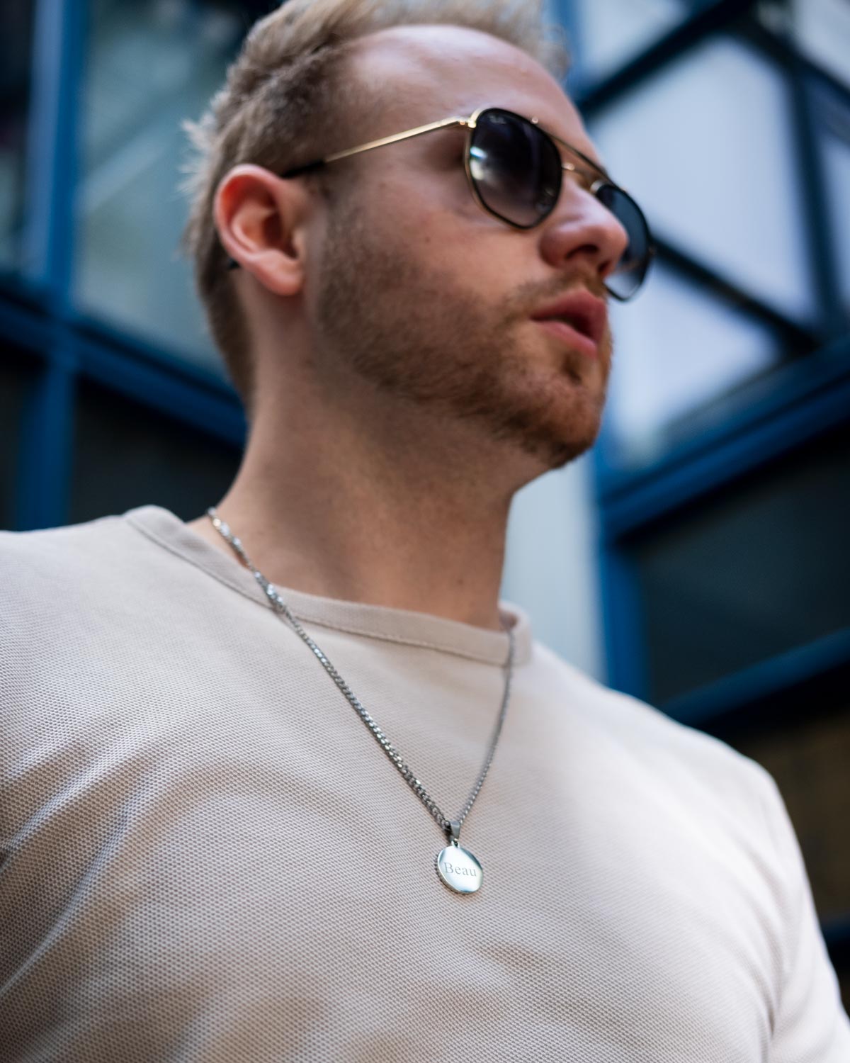 man draagt zilveren ketting graveerbare munt