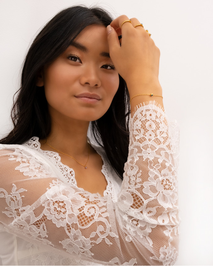 model met zwart haar kanten top en birthstone sieraden