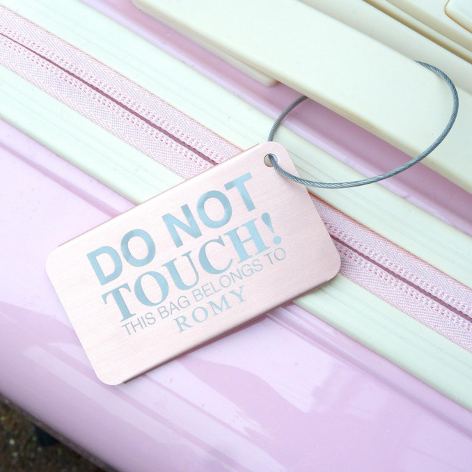 kofferlabel aan roze koffer