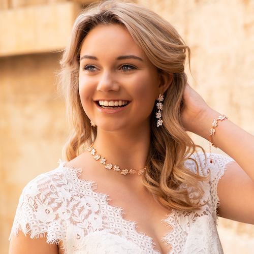 Rose gouden sieraden set bij blond meisje met krullen