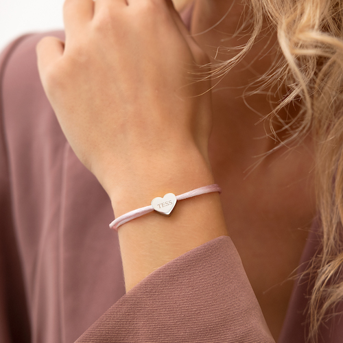 Roze satijnen armbandje met zilveren hartjes bedel om pols