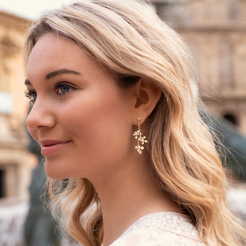 gouden boho oorbellen met pareltjes in oor van model