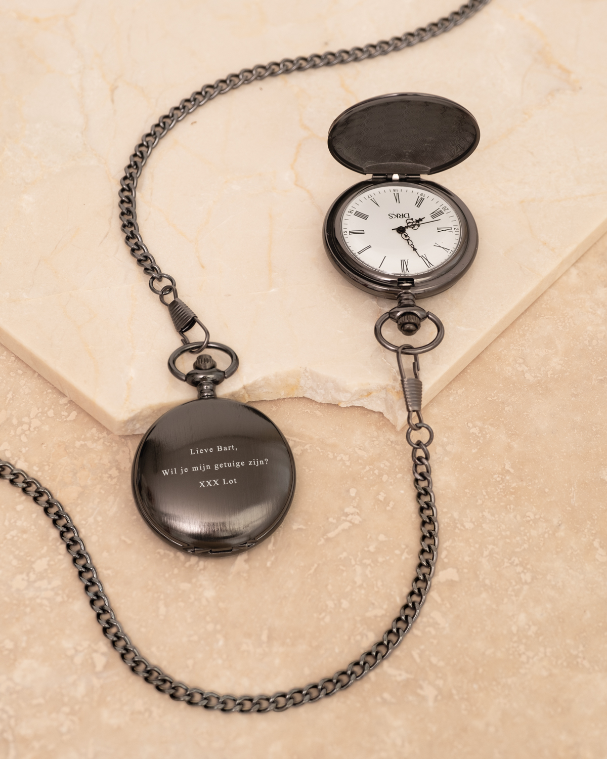 zwarte pocket watch gravering met marmer ondergrond