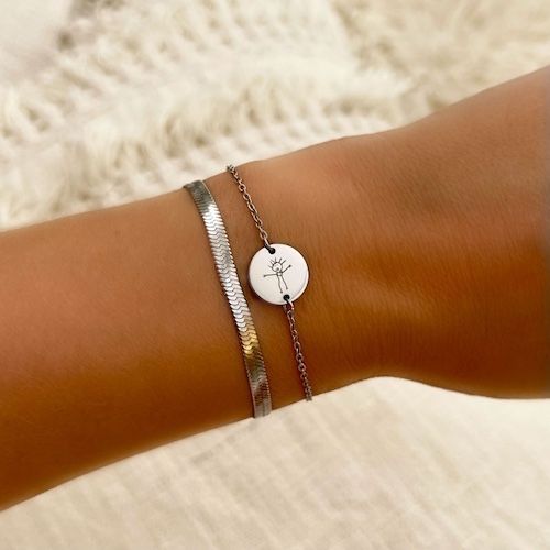 Zilveren armband met persoonlijke tekening om pols.